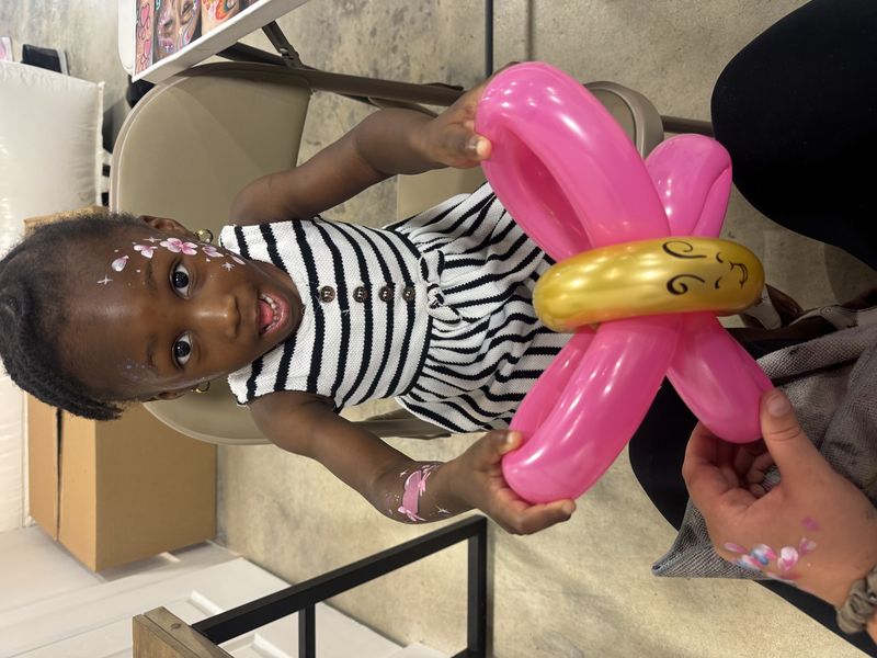 Pink and gold butterfly balloon at a floral face paint event in Texas