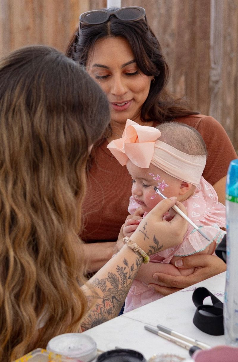 Baby flower face painting at a Texas birthday party