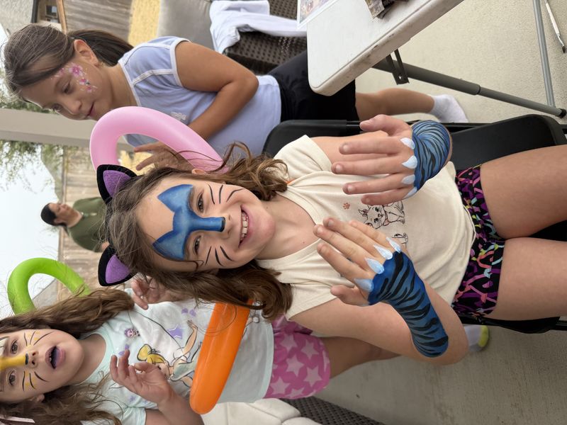 Tiger face painting with paw hands at a Texas kids birthday party